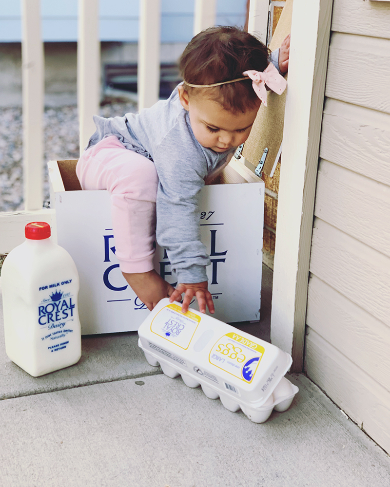 Small child on her front porch, with Royal Crest Milk and Eggs.